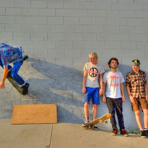 Four young people enjoying and practicing skateboarding