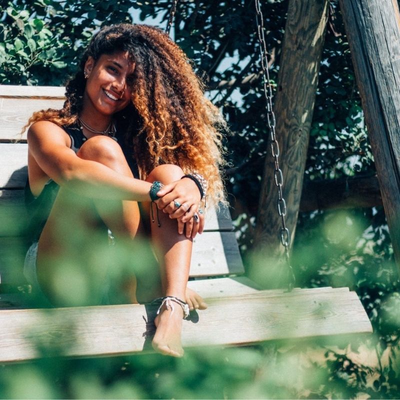 Woman sitting outside, smiling and enjoying the environment 